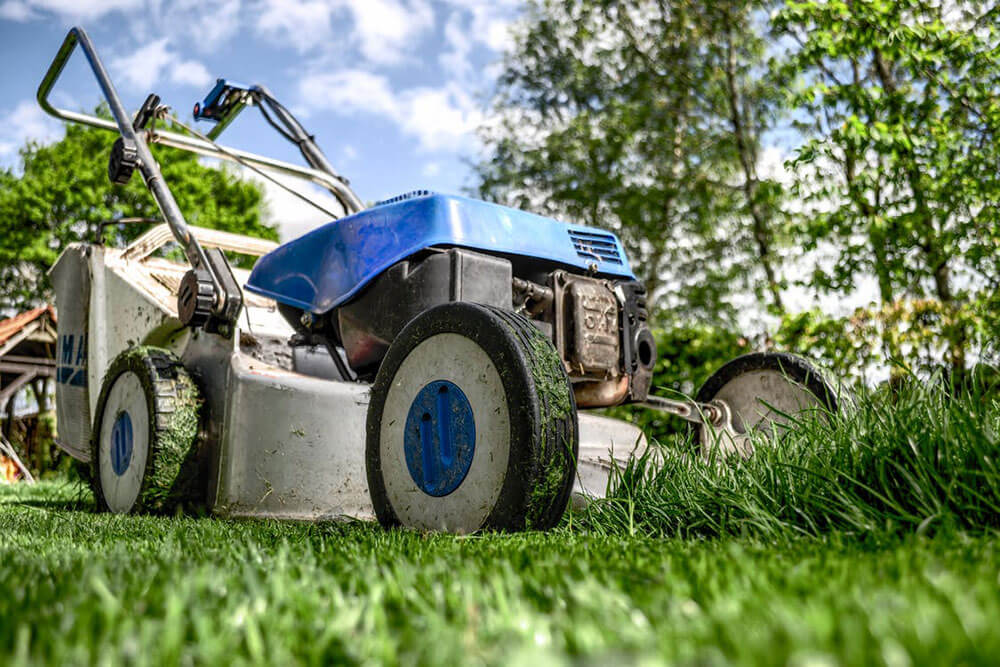 Lawnmower mowing a lawn in spring