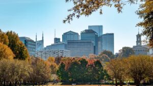 A colorful cityscape with buildings, skyscrapers, trees, and blue sky.